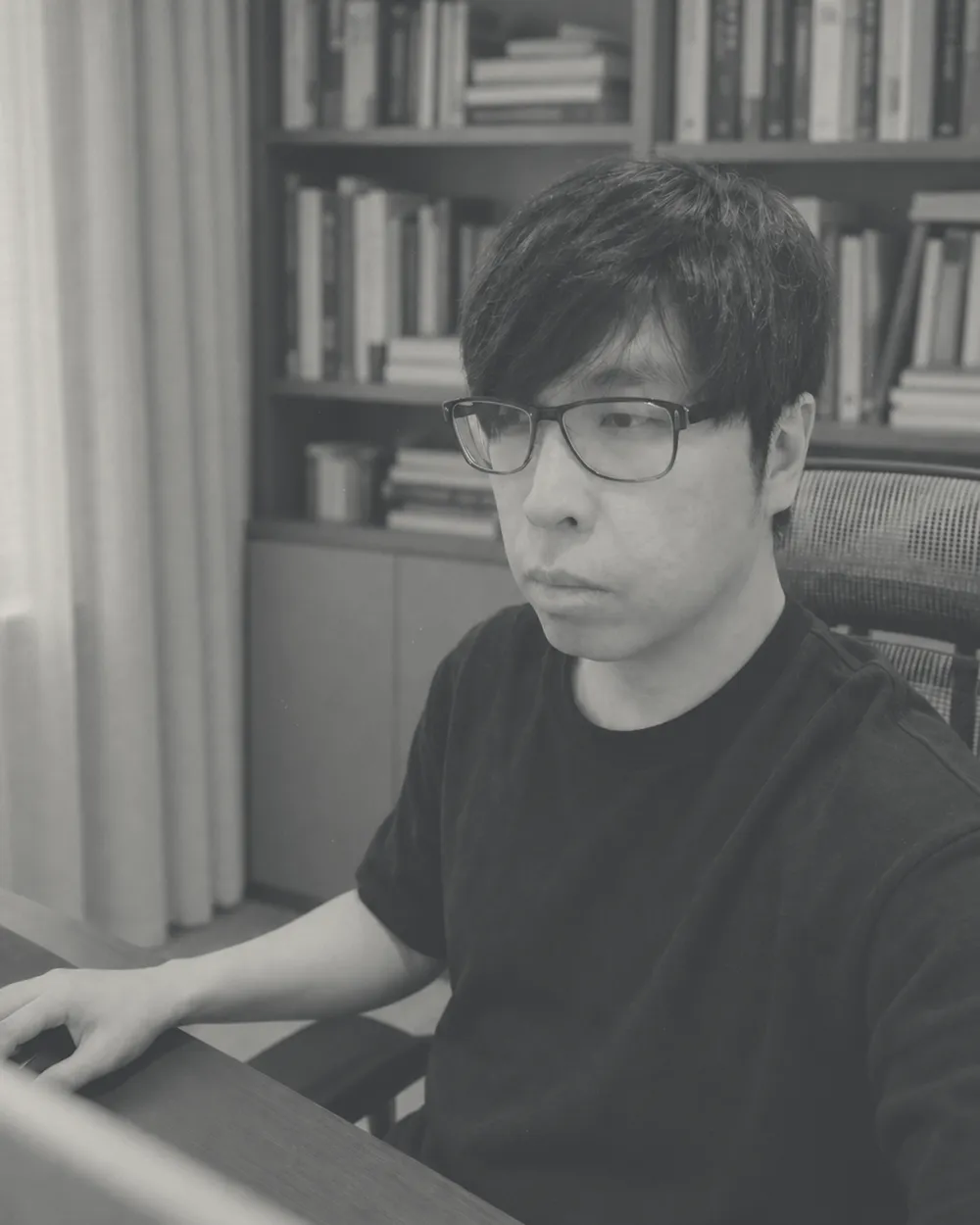 邱維添在書房的電腦前工作